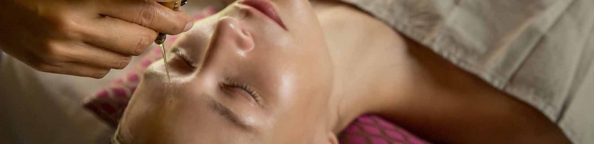 massage shirodhara sur le visage d'une femme