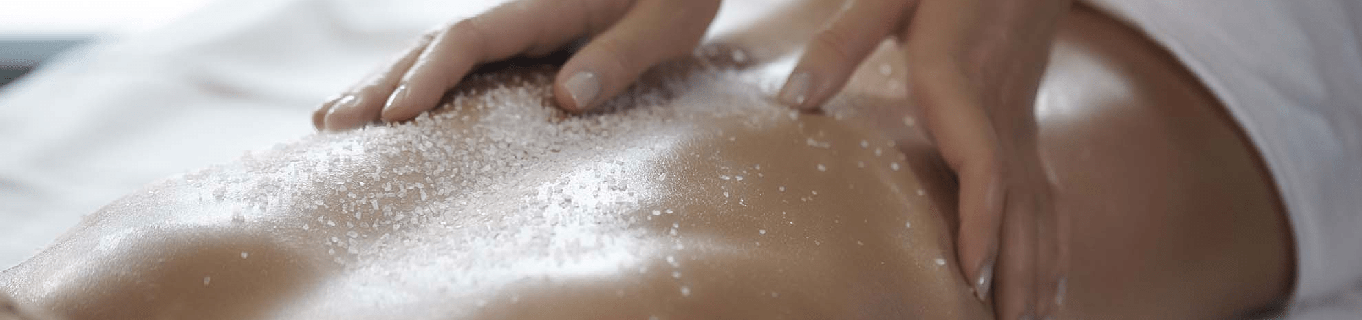 femme durant un gommage du corps au spa