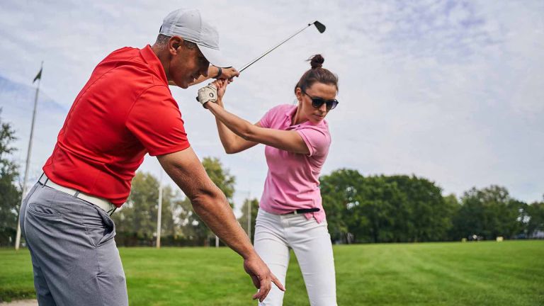deux personnes durant un cours de golf