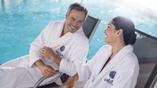 Couple sur des transats au bord d'une piscine thalasso