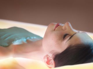 Femme durant un enveloppement d'algues sur lit hydrosensoriel