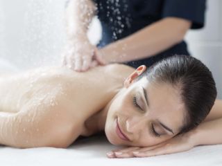 Femme durant un massage sous pluie marine
