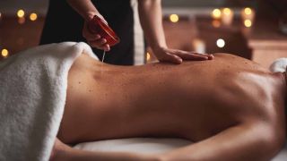 personne réalisant un massage aux huiles essentielles apaissantes sur le dos d'une femme