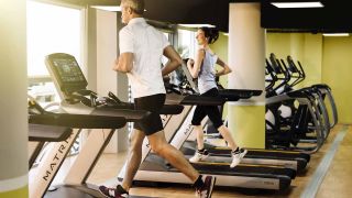Une femme et son coach sur un tapis de course