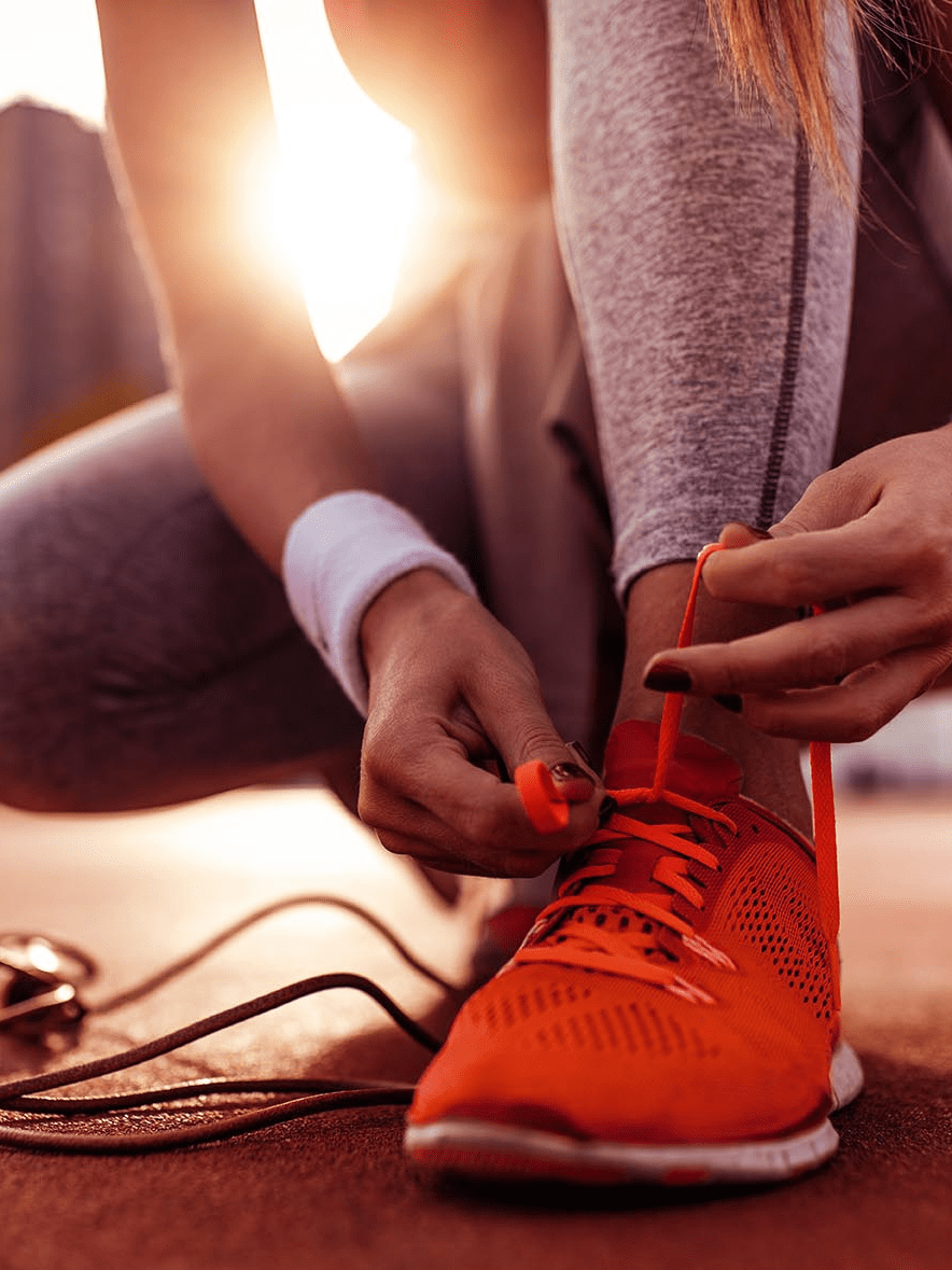 femme qui lace ses chaussures de sport